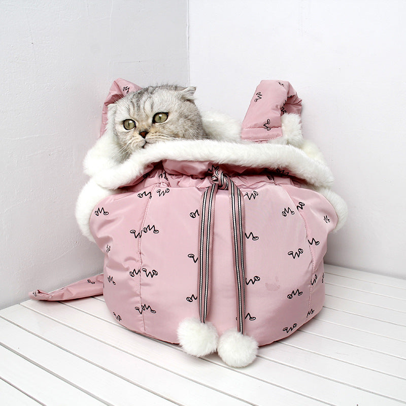 Cat inside a pink puffer bag with white fur trim on a white wooden floor.