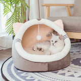 Cat lying in a heart-shaped pet bed with a plant and chair in the background