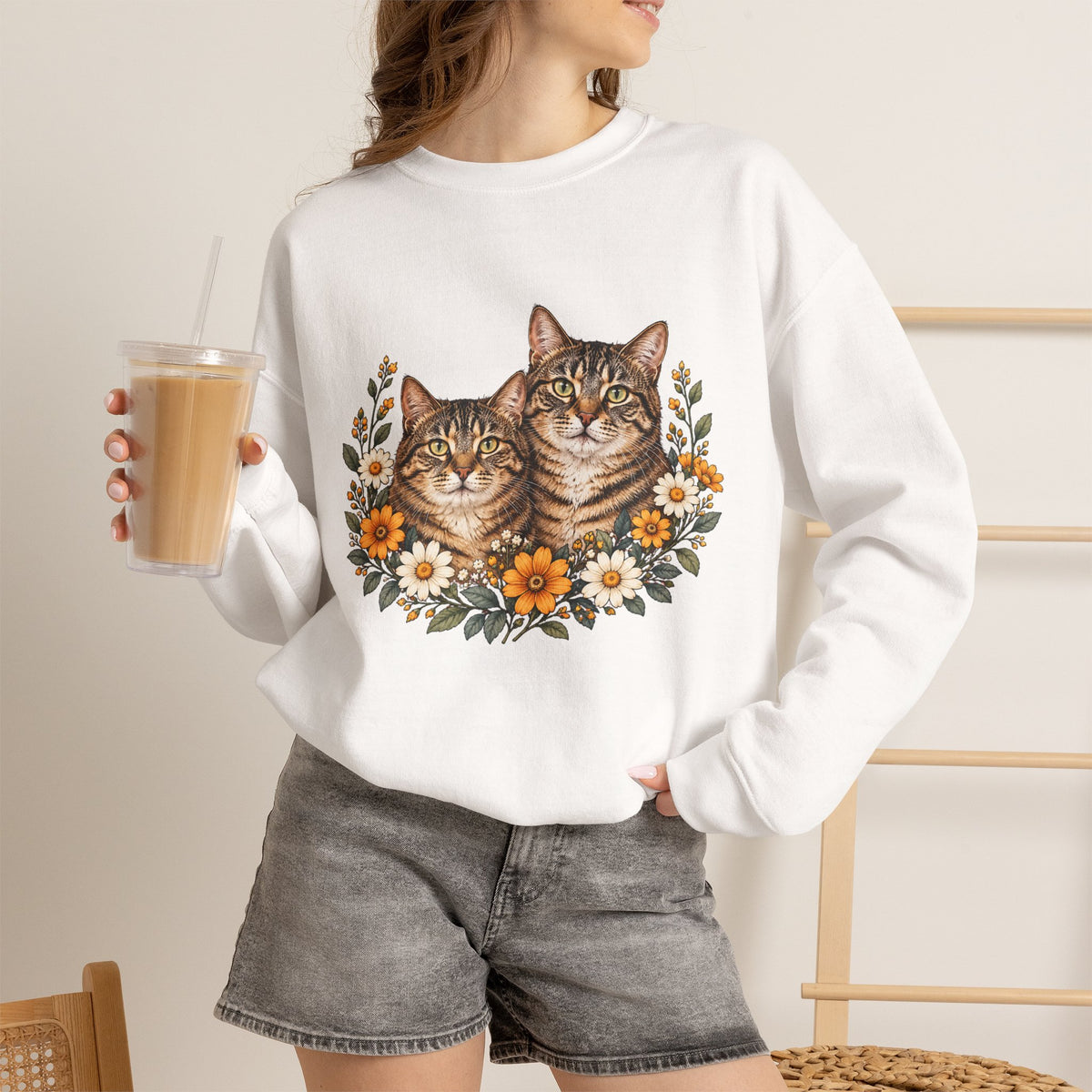 Two tabby cats and wildflowers printed on a black unisex crewneck sweatshirt