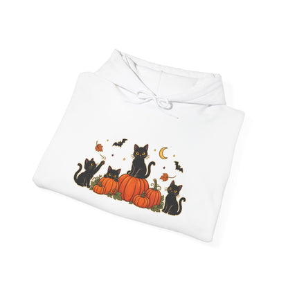 A white pullover hoodie with a front graphic of black cats sitting on orange pumpkins, surrounded by small bats, leaves, and a crescent moon, shown on a plain white background.