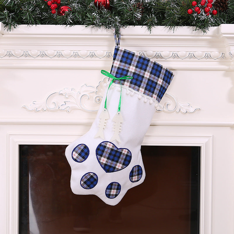 White paw-shaped Christmas stocking with blue plaid cuff, matching paw pads, and green ribbon