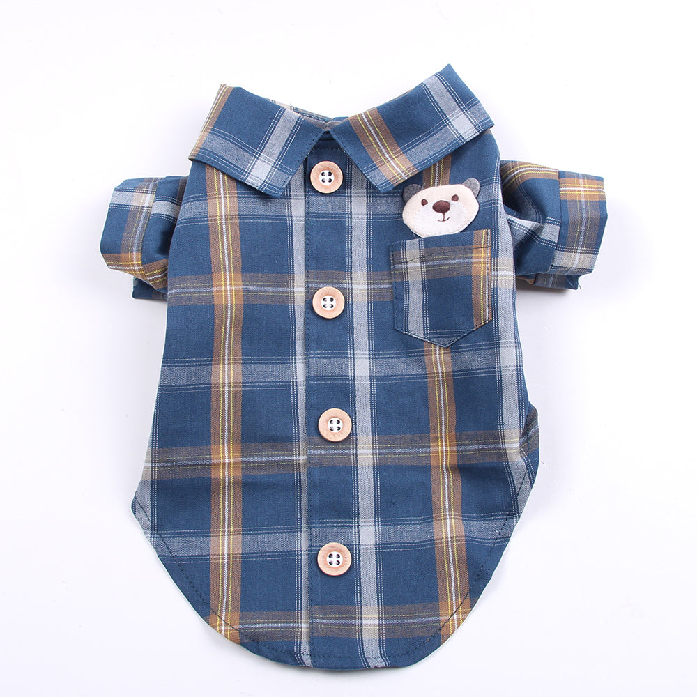 Blue plaid dog shirt with bear design and buttons on a white background