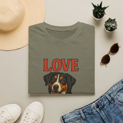 Green t-shirt with a dog illustration and 'LOVE' text, surrounded by casual items on a light surface.