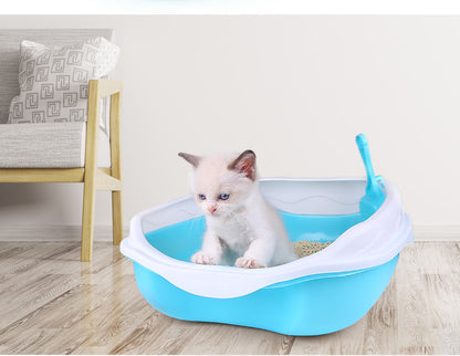 Kitten inside a blue pet litter box on a wooden floor with a chair and pillow in the background.