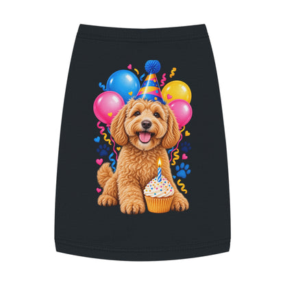 A black tank top shirt for your dog featuring a colorful graphic print of a fluffy golden-brown dog wearing a party hat, surrounded by pink, blue, and yellow balloons, a cupcake, and small heart and confetti details.