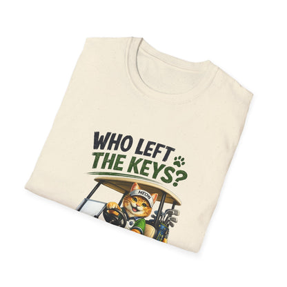 A folded cream-colored t-shirt with a graphic print of a cartoon cat driving a golf cart, with the text 'WHO LEFT THE KEYS?' in dark green and black lettering.