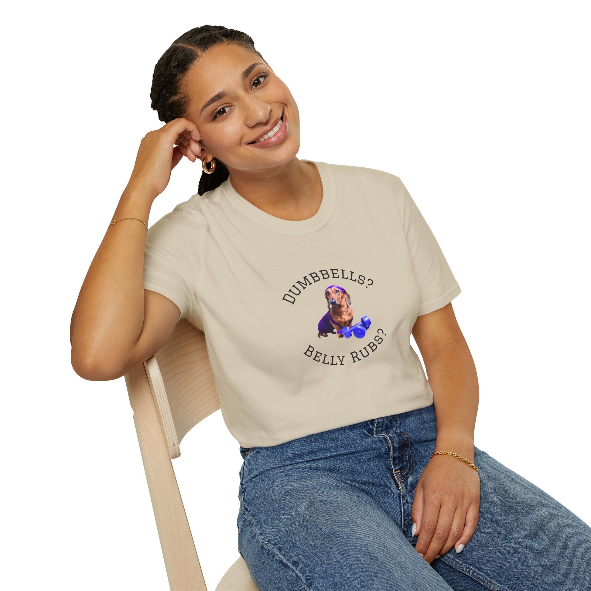 Person wearing a beige t-shirt with a graphic and text, sitting on a chair.