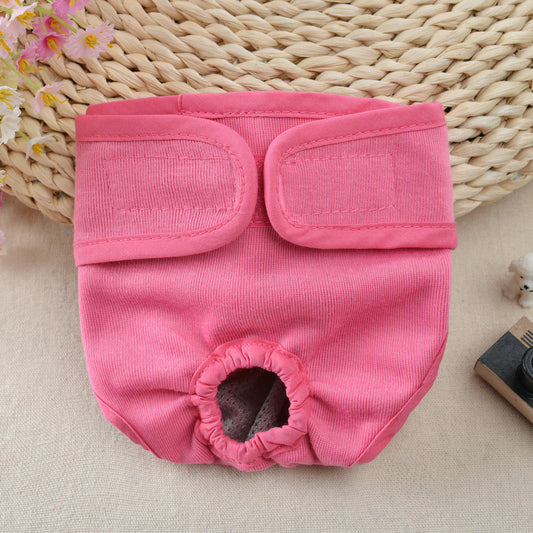 Pink dog diaper on a textured surface with a woven basket in the background