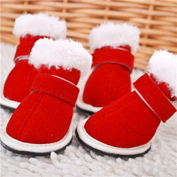 Red pet boots with white fur on a textured surface