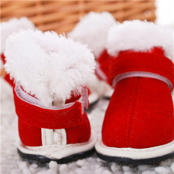 Red and white baby shoes with fluffy texture on a textured surface
