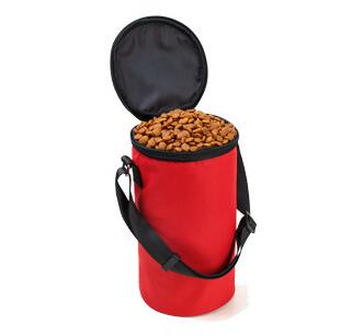 Red pet food bag with black lid and handle filled with dog food on a white background