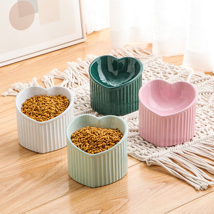 Four heart-shaped ceramic bowls on a wooden floor with macrame rug