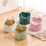 Four heart-shaped ceramic bowls on a wooden floor with macrame rug