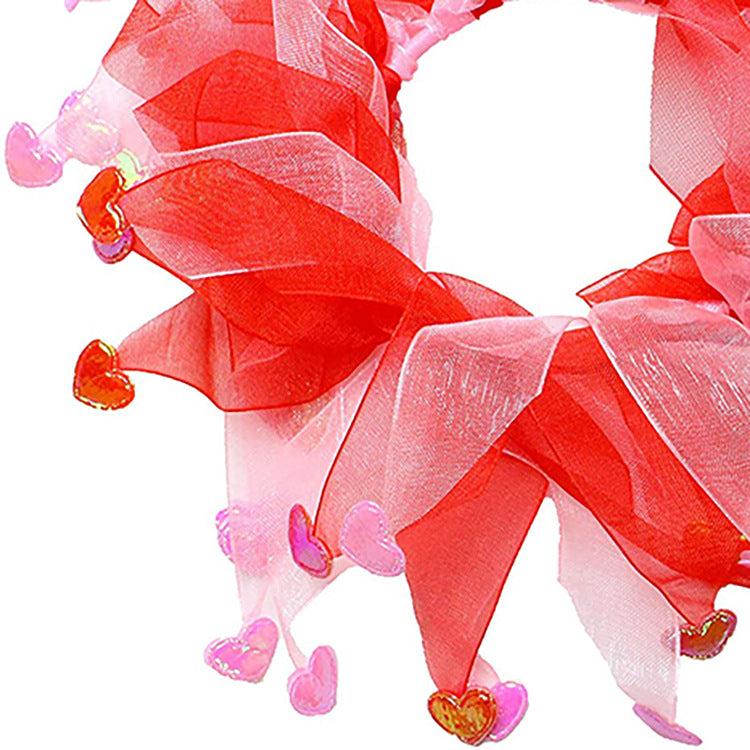 Red and pink decorative wreath with heart-shaped ornaments on a white background