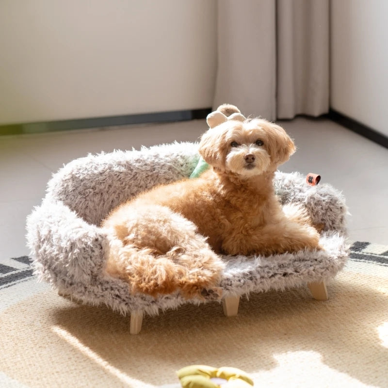 Small dog sitting on a fluffy pet bed in a room with light-colored walls.