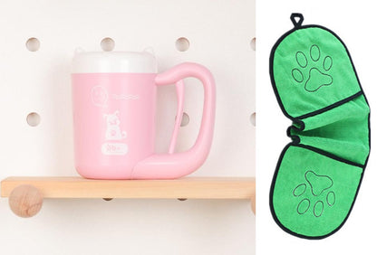 Pink mug on a wooden shelf with a green paw print oven mitt next to it.