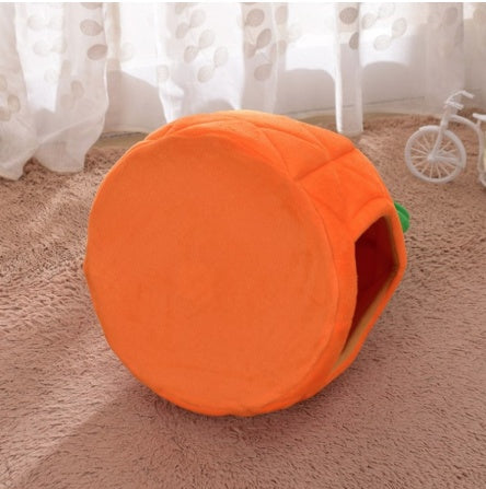 Orange pet house shaped like a carrot on a carpeted floor with curtains in the background