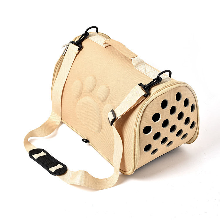 Beige pet carrier with black straps on a white background