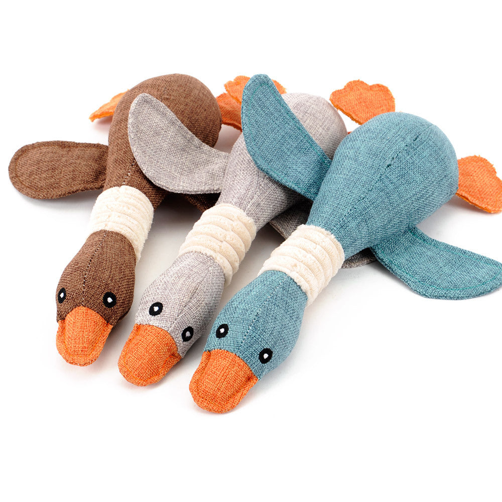 Three toy ducks in brown, gray, and blue with orange beaks on a white background