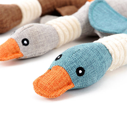 Close-up of knitted duck toys with colorful beaks and feet on a white background