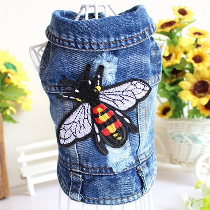 Denim dog vest with a bee patch on a stand with sunflowers in the background