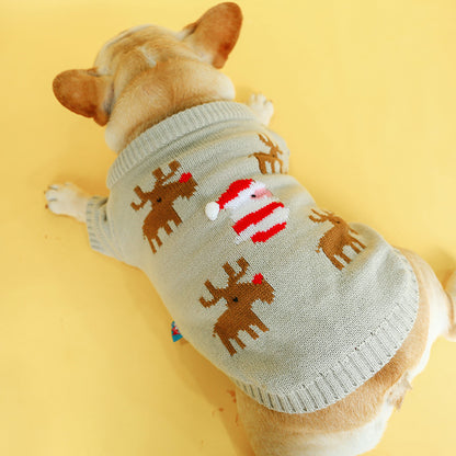 Dog wearing a sweater with reindeer and Santa Claus design on a yellow background