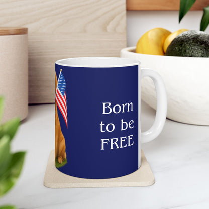 Mug with 'Born to be FREE' text and American flag on a coaster, placed on a surface with plants and fruit in the background.