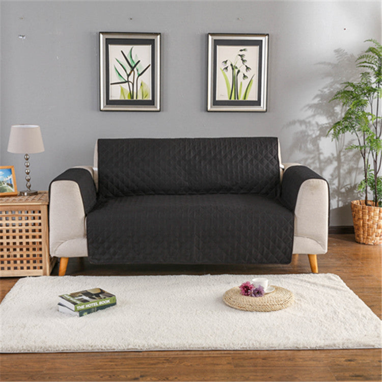 Sofa with a black quilted cover in a living room setting.