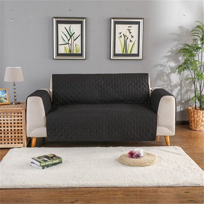 Sofa with a black quilted cover in a living room setting.