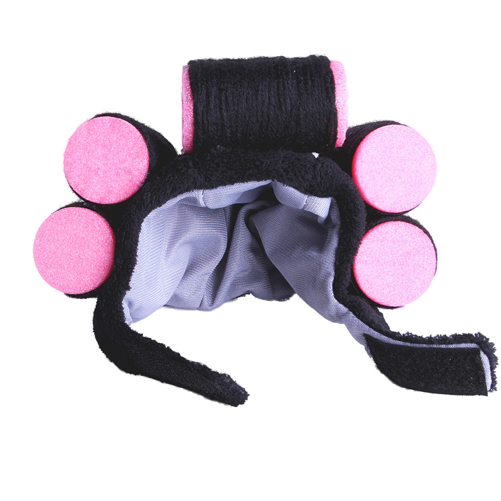 Black headband with pink circular pads on a white background