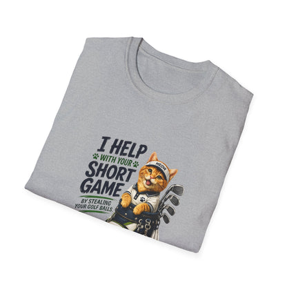 A sport grey graphic T-shirt is displayed in a styled flat lay on a light beige surface. The shirt features a cartoon cat wearing a baseball cap and holding golf clubs, with the text 'I HELP WITH YOUR SHORT GAME BY STEALING GOLF BALLS.