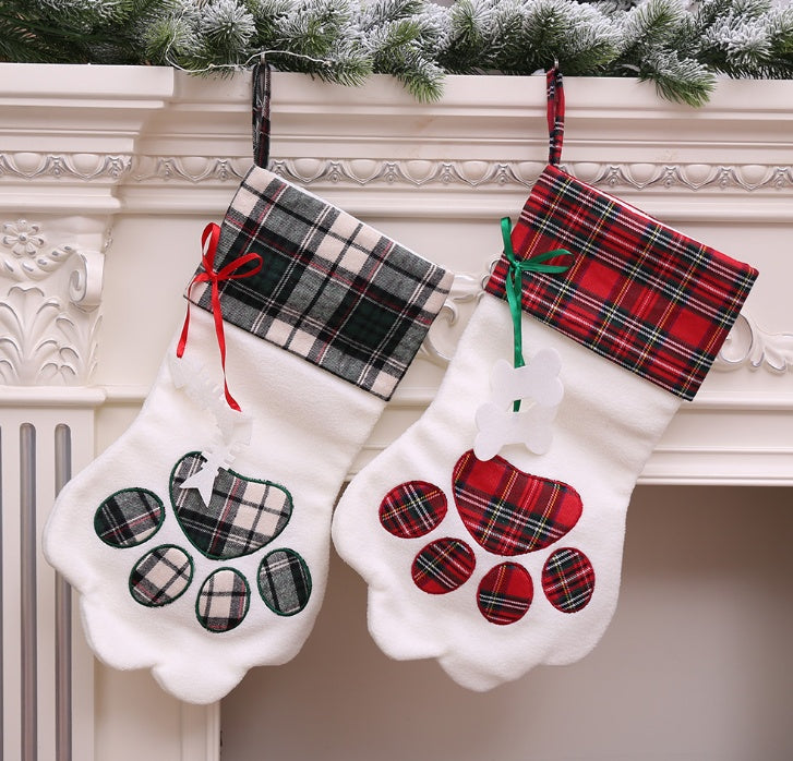 Dark green and red plaid paw-shaped Christmas stockings hanging from a mantel