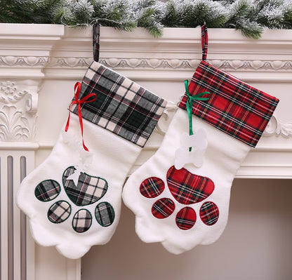 Dark green and red plaid paw-shaped Christmas stockings hanging from a mantel