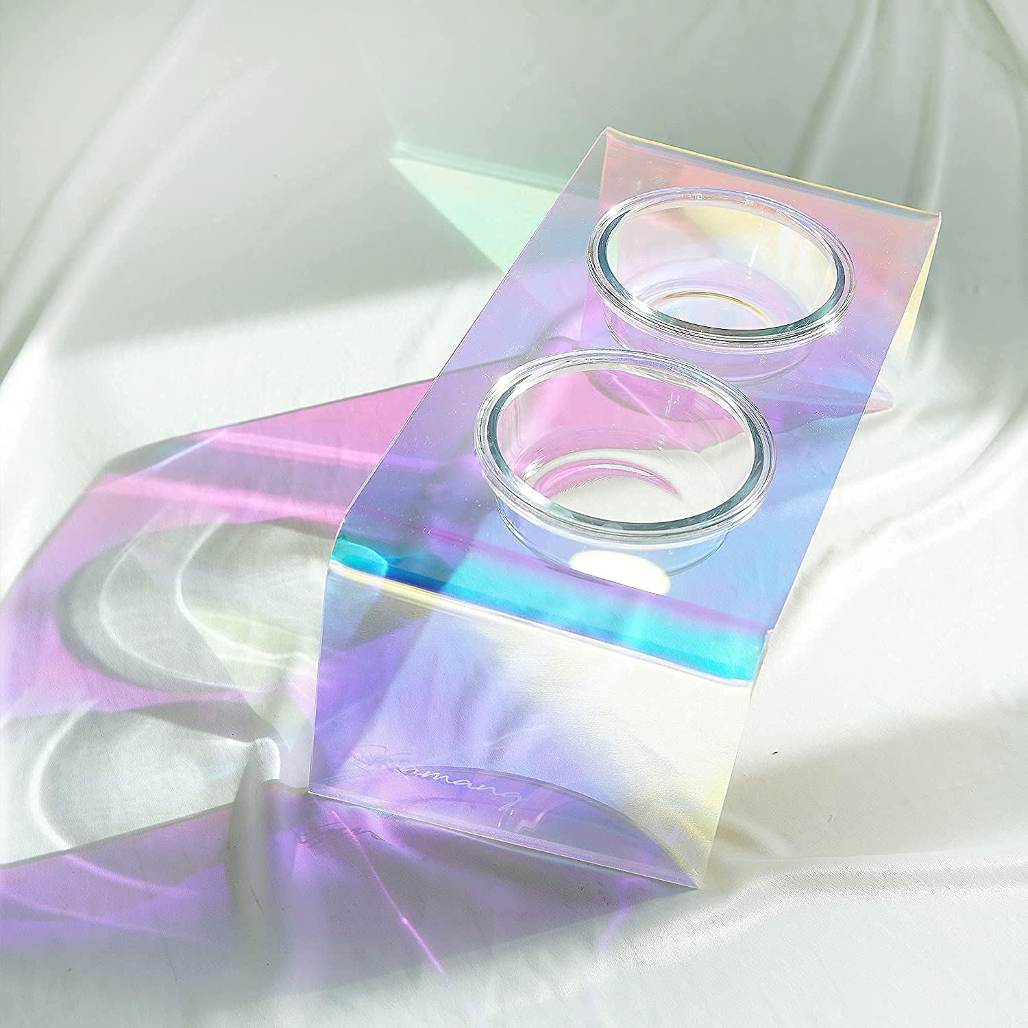 Holographic packaging with two round containers on a white fabric background