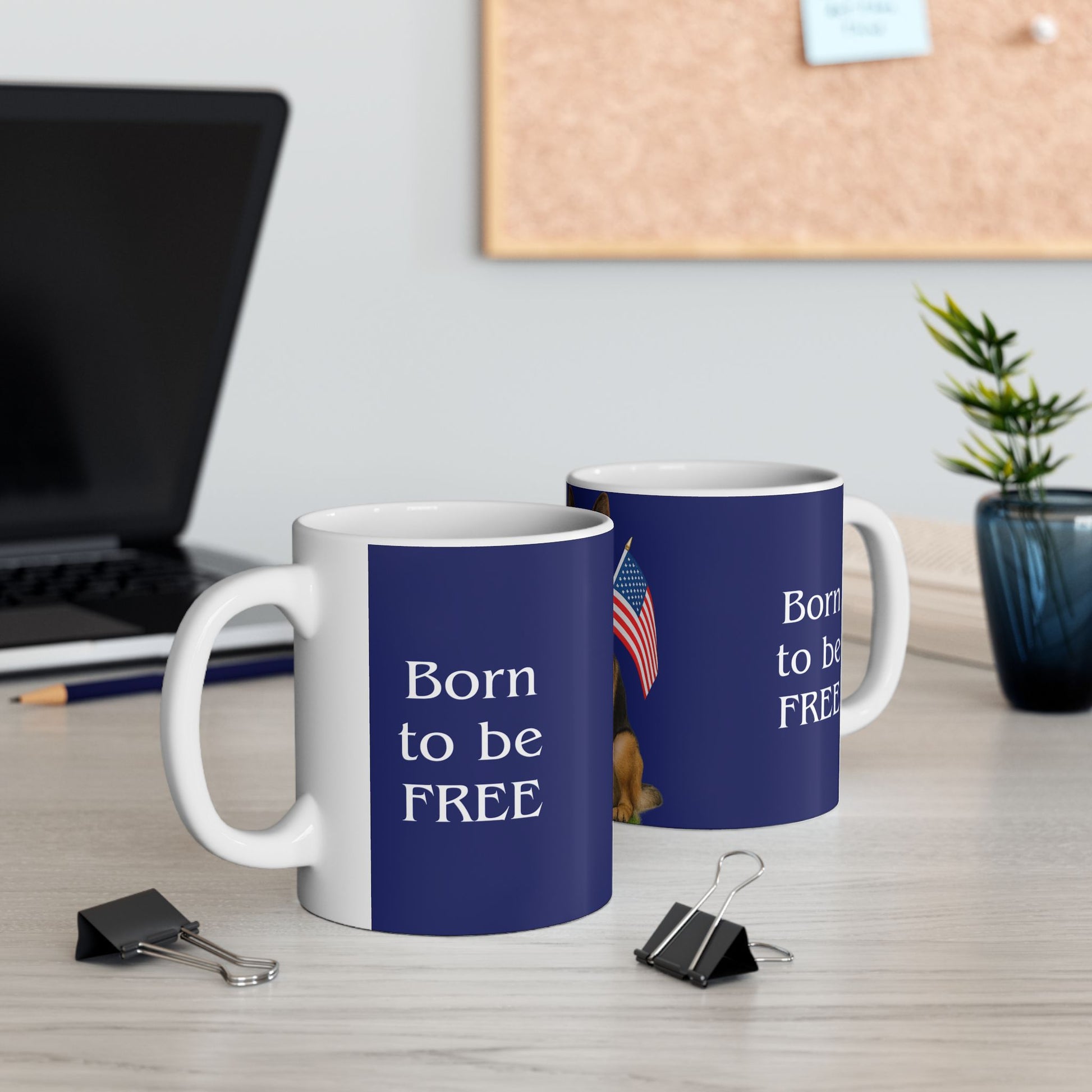 Two blue mugs with 'Born to be FREE' text on a desk with office supplies.