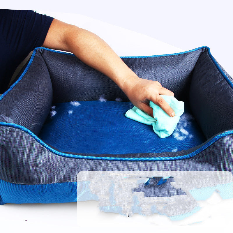 Person cleaning a blue pet bed with a green cloth.