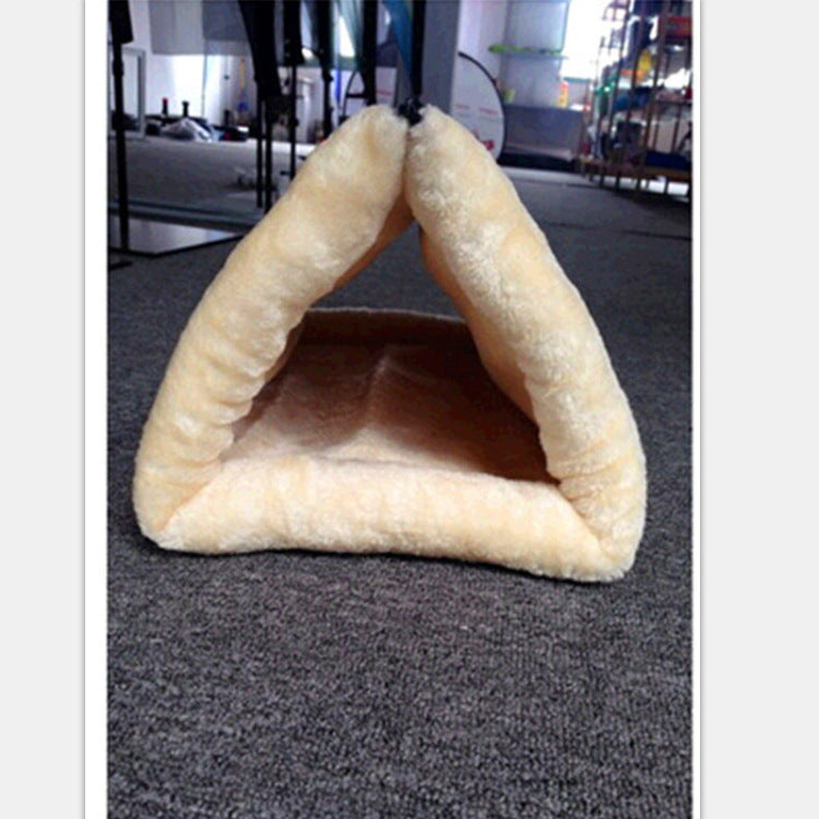 Triangular pet bed on a carpeted floor with a blurred background