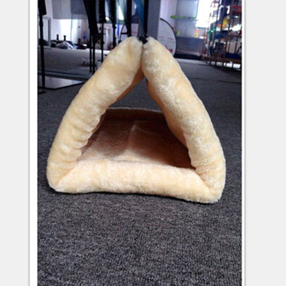 Triangular pet bed on a carpeted floor with a blurred background