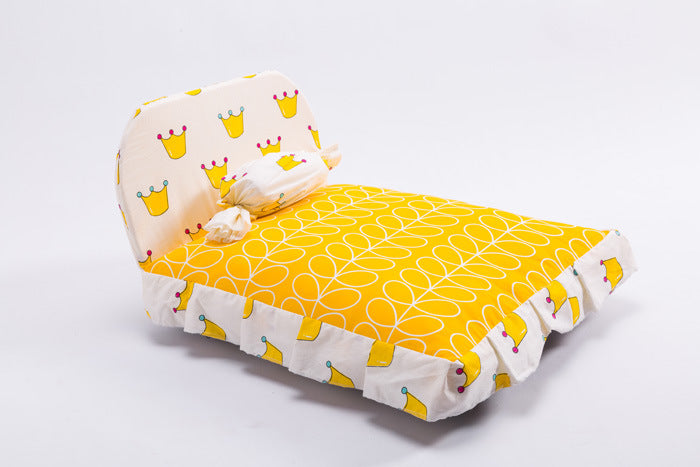 Yellow baby crib bumper with crown pattern on a white background