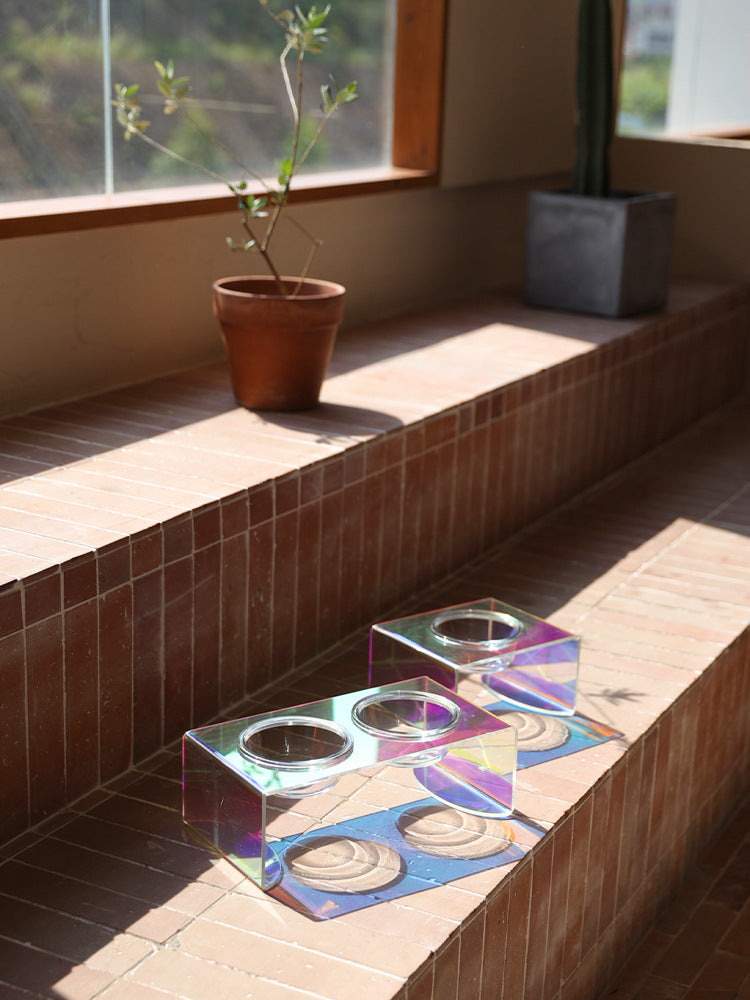 Iridescent glass tray on a tiled ledge with a plant in the background
