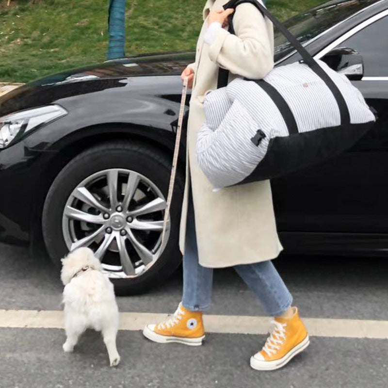 Person with a dog by a car, wearing a beige coat and orange sneakers.