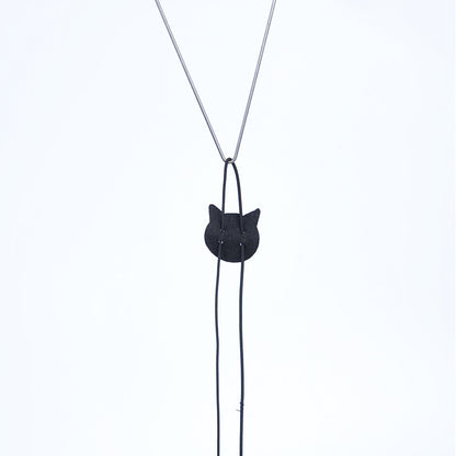 Black cat-shaped pendant on a silver chain against a white background
