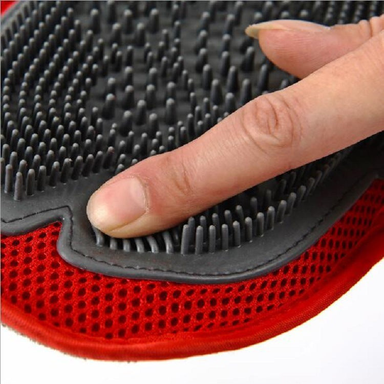 Red and black grooming brush with a hand pressing on it