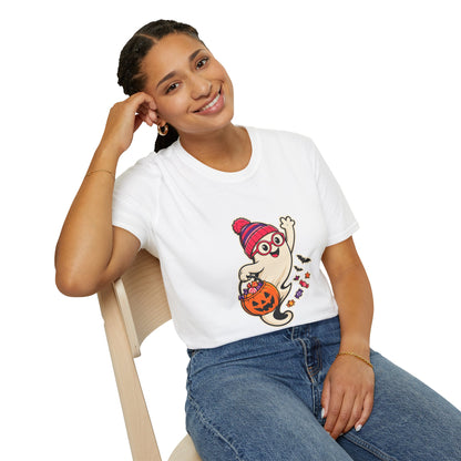 A woman wearing a white graphic t-shirt with a cartoon ghost holding a jack-o'-lantern, sitting on a wooden chair against a white background.