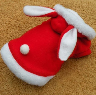 Red and white plush toy with bunny ears on a brown surface