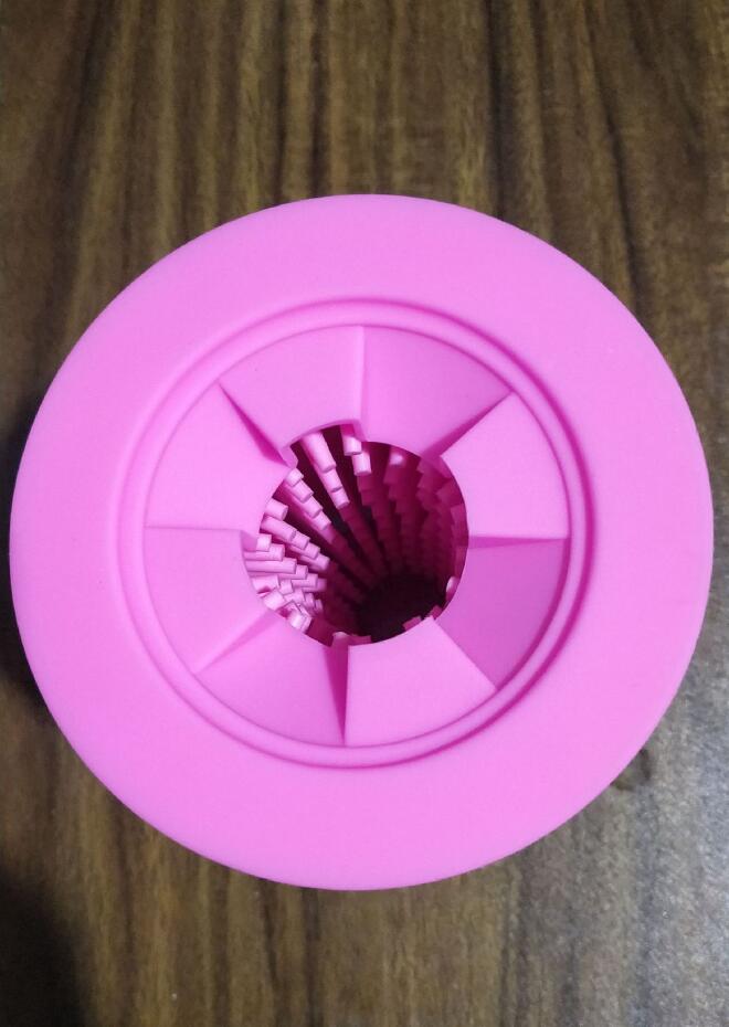 Pink bottle cap with a metal filter on a wooden surface