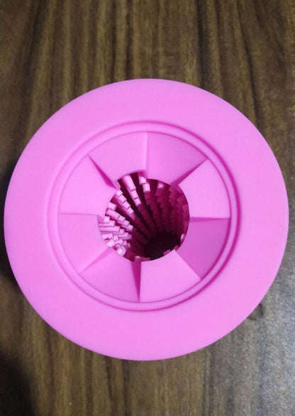 Pink bottle cap with a metal filter on a wooden surface