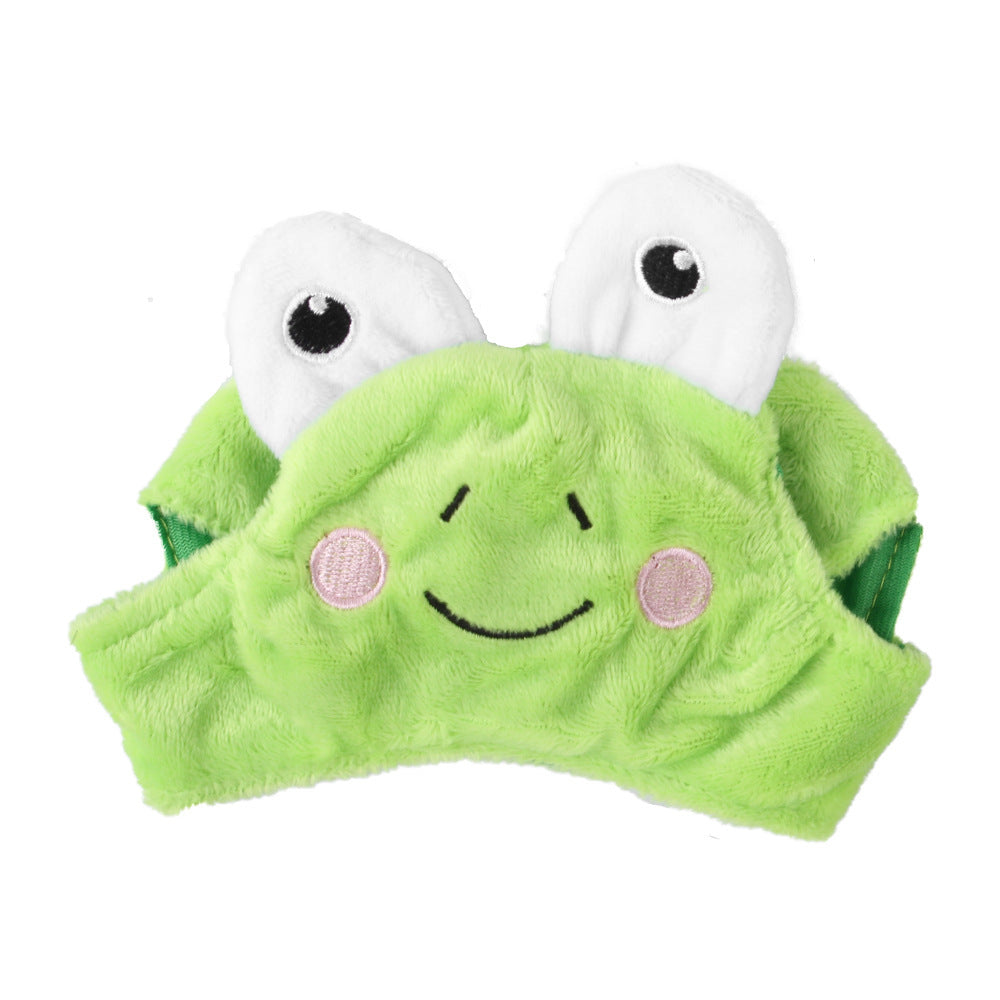Green plush toy with white eyes and a smiling face on a white background