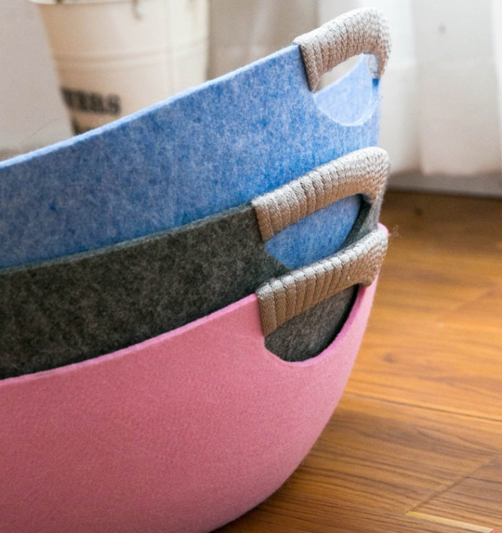 Stack of colorful felt baskets on a wooden floor