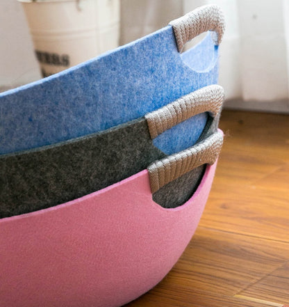 Stack of colorful felt baskets on a wooden floor